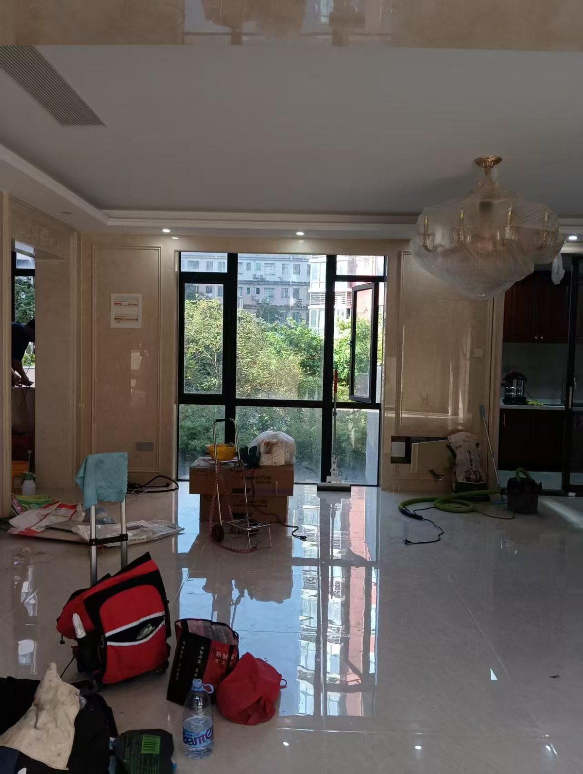 深圳龙岗新生深房尚林花园别墅旧改新开荒，客厅清理前，地面堆着工具与包装