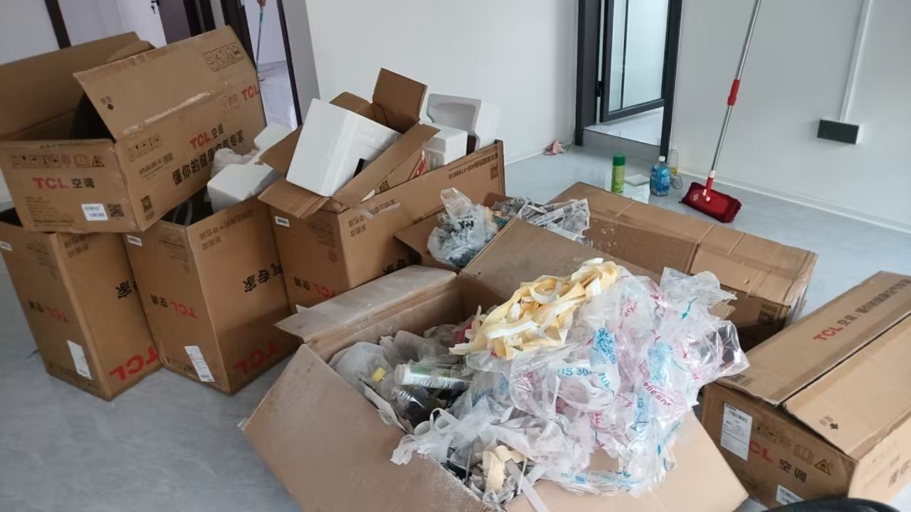 深圳新房开荒前的客厅现场,装修撤场后包装箱、泡沫与碎料集中堆放